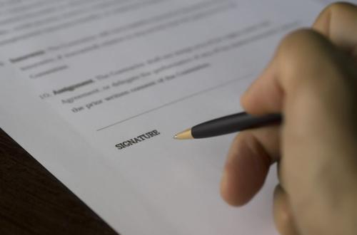 Mano che firma un documento, simbolo di impegno e responsabilità.